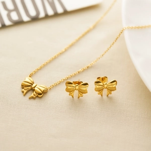 Polished 18K gold-plated stainless steel ribbon bow necklace and stud earrings set