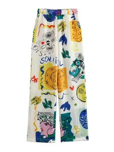 Détail macro du pantalon large à taille haute avec imprimé artistique et texture soyeuse