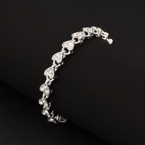 Close-up of silver heart bracelet with cubic zirconia on black curved surface