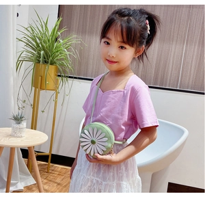 Close-up of a round light green children's crossbody bag featuring a 3D daisy flower detail