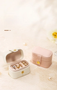 Mini PU leather travel jewelry case in pink and white with ring slots and snap button