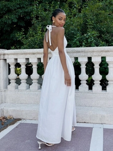 Detail of the white halter backless dress showing soft cotton fabric and tie-back closure
