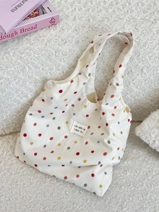 Sac fourre-tout en toile à pois colorés avec étiquette de marque sur fond blanc