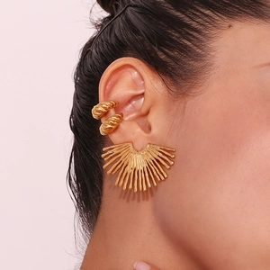 Detail of 18K gold plated ray-shaped fan earrings and textured ear cuff set on model