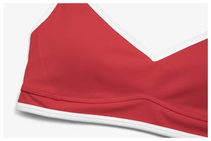 Close-up of contrast white piping on deep red sports bra with high-elastic fabric detail
