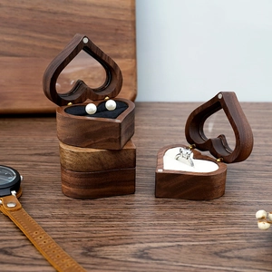 Close-up of heart-shaped walnut wood jewelry box with transparent lid and magnetic closure