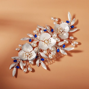 Detailed shot of silver bridal hair comb with pearls, blue beads, and alloy flowers