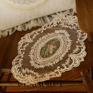 Oval ivory lace placemat with floral embroidery on vintage wooden chair backdrop