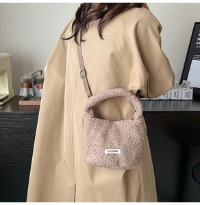 Détail du sac seau en peluche rose avec étiquette CLEAR K et bandoulière réglable
