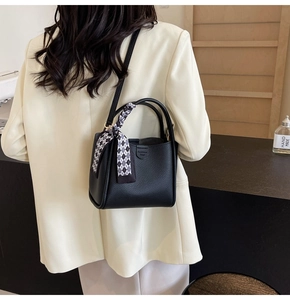 Black litchi pattern bucket bag styled with a geometric silk scarf on a chic model