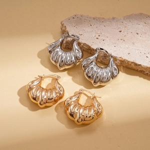 Irregular geometric shell earrings in gold and silver finish on textured stone
