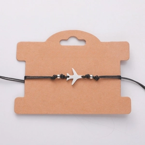 Detail van de verstelbare zwarte wax touw armband met een roestvrijstalen vliegtuig hanger