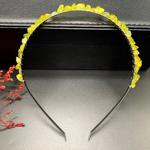 Macro detail of handmade silver wire wrapped lime green crystal stones on the headband