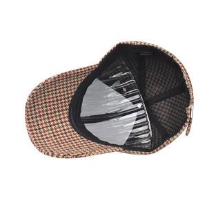 Dettaglio della fodera del cappellino pied-de-poule con supporto interno ed etichetta