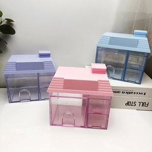 Vista de detalle de cajas de almacenaje en forma de casa con cajones en rosa, lila y azul