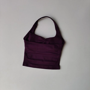 Detailed view of dark purple halter neck yoga top with gathered front and seamless fabric