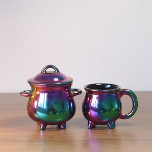 Macro view of rainbow ceramic witch cauldron and mug with iridescent glaze finish