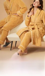 Detailed texture of thick ginger fleece pajama set with white piped edges on soft sofa