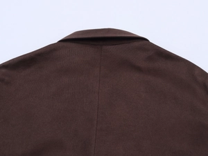 Détail du dos d'une chemise en daim marron foncé montrant les coutures et le col texturé
