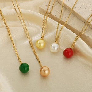 Colliers élégants en titane doré avec perles de nacre sur tissu en soie beige