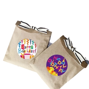 Kraft gift bags with striped bows and colorful Happy Birthday sealing stickers on white background