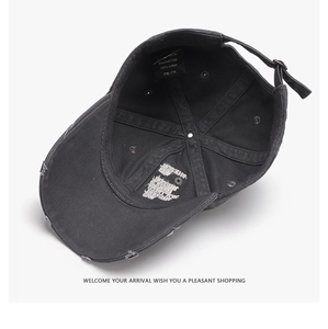 Detail of grey cotton baseball cap interior showing stitching and 100% cotton wash label