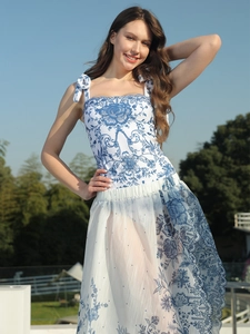 Detail of blue floral print swimsuit featuring shoulder bow ties and a sheer sarong skirt