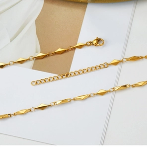 Detail view of 18K gold plated herringbone chain with geometric diamond beads and lobster clasp
