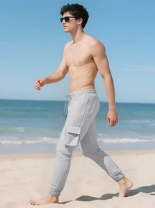 Detail of gray cargo pants with elastic drawstring waist and side flap pocket outdoors