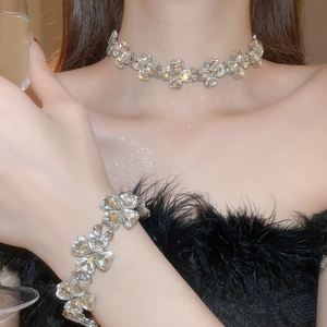 Close-up of sparkling heart teardrop crystal necklace and bracelet set on model