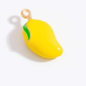 Détail macro d'un pendentif mangue en alliage avec émail jaune et breloque feuille verte