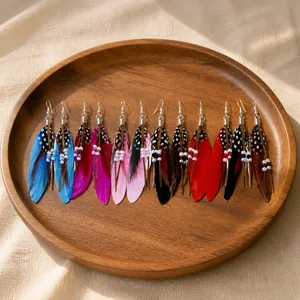 Close-up of bohemian feather earring set with colorful beads and metal hooks