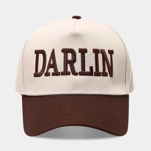 Close-up of DARLIN embroidery on a two-tone beige and brown vintage trucker hat