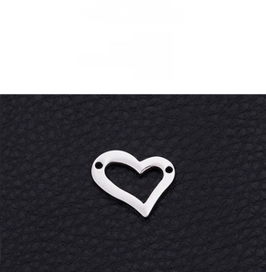 Detail of heart pendant with 18K gold vacuum plating on a black textured surface