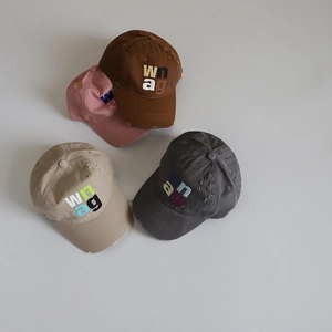 Detail of four colorful distressed cotton baseball caps with embroidered wnag letters