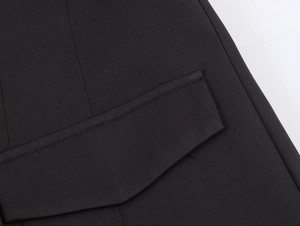 Detailed close-up of premium black woven fabric texture and stitching on the blazer pocket