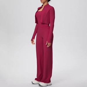 Détail de l'ensemble de yoga magenta montrant les poignets passe-pouce et la veste