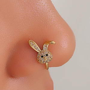 Macro shot of gold non-piercing U-shaped rabbit nose clip with cubic zirconia inlay