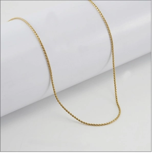 Detailed view of 18K gold plated stainless steel S-chain necklace on a white pedestal