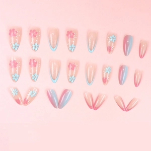 Blue and pink floral press-on nails set with glitter gradient on a pink background