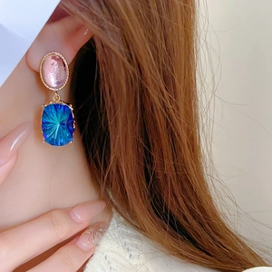 Macro shot of vintage style earrings with pink and green crystals on a model