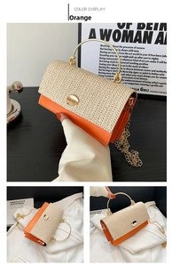 Detail view of woven straw and orange leather handbag with golden ring handle and chain