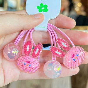 Dettaglio dell'elastico rosa per capelli con ciondolo a coniglio glitterato e perline