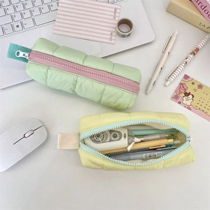 Quilted macaron pencil case showing spacious interior storage with colorful pens and tapes