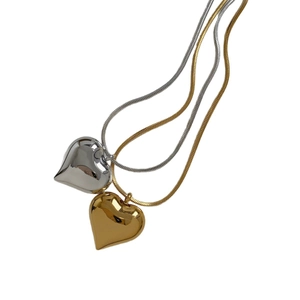 Minimalist gold and silver heart pendant necklaces featuring sleek snake chains