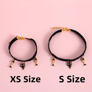Detail of adjustable black velvet pet collars with gold cat and fish pendants, sizes XS and S