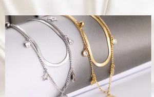 Macro detail of a double-layered gold bracelet with evil eye star charms and zircon pendants
