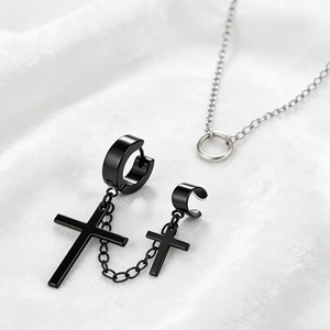 Detail of black stainless steel cross earrings with chain link on white fur background
