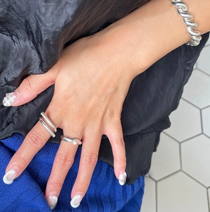 Detail of 925 silver geometric minimalist rings and twisted rope bracelet on model hand