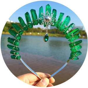 Handcrafted sun charm tiara with green crystal points on a gold metal headband